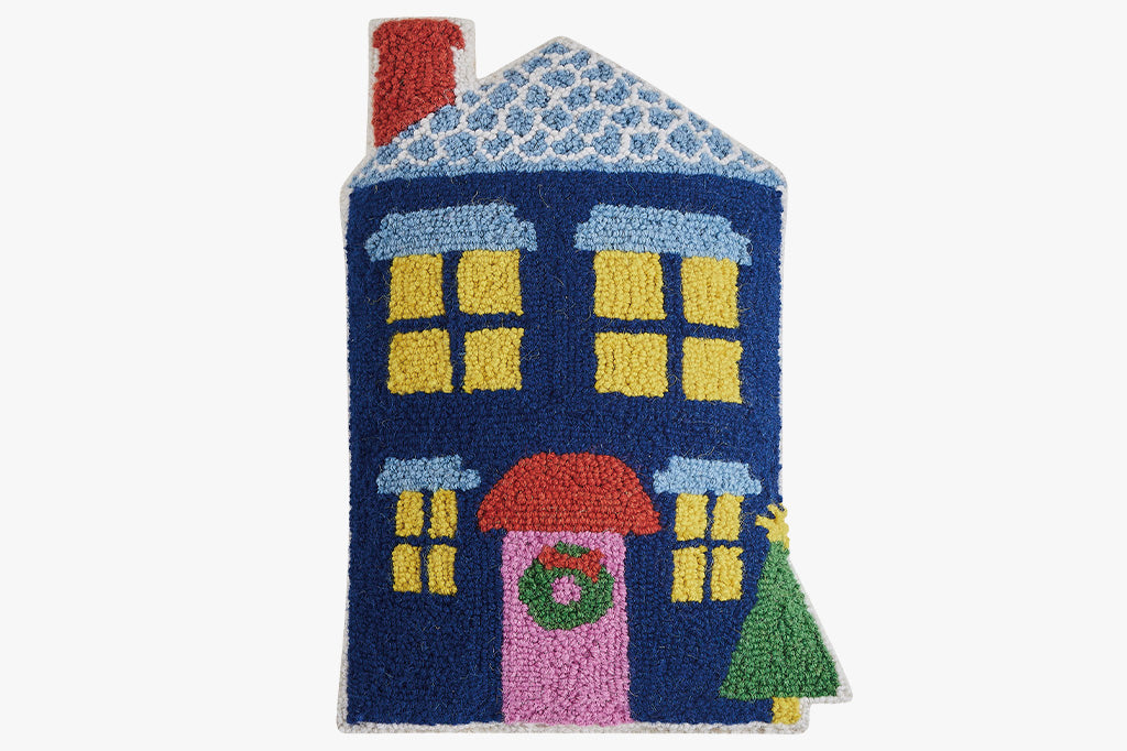 hooked wool pillow features a charming blue house shape with christmas wreath and tree on porch