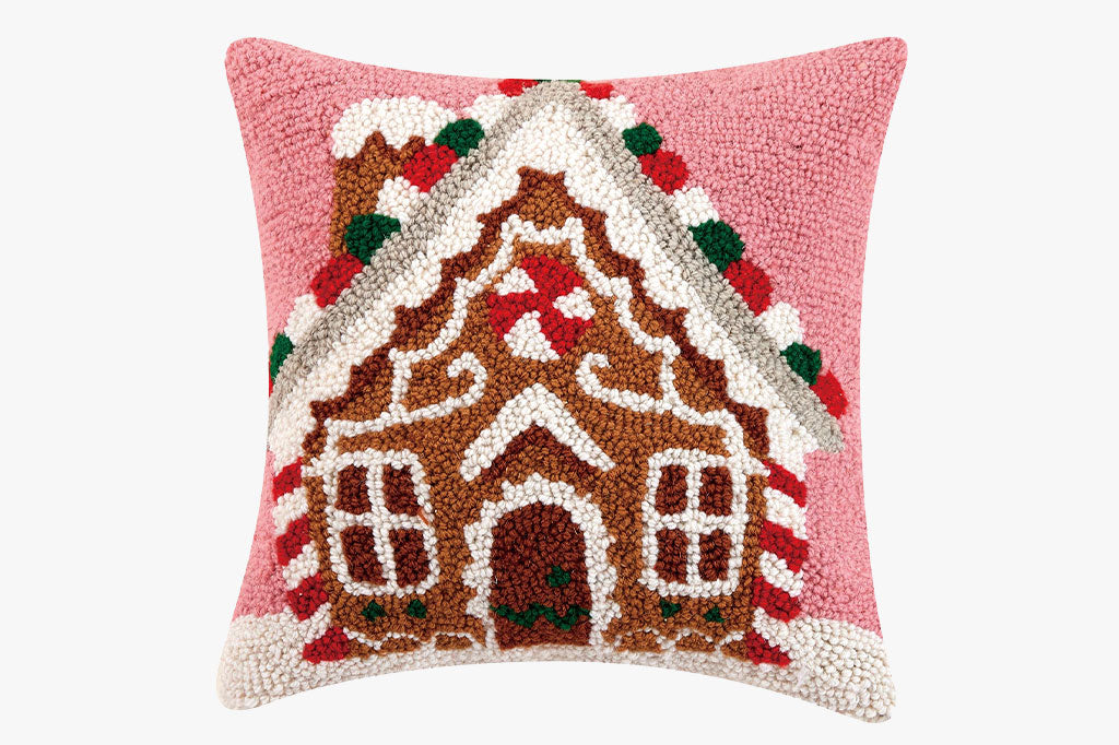 hooked pillow featuring a gingerbread house design on pink background