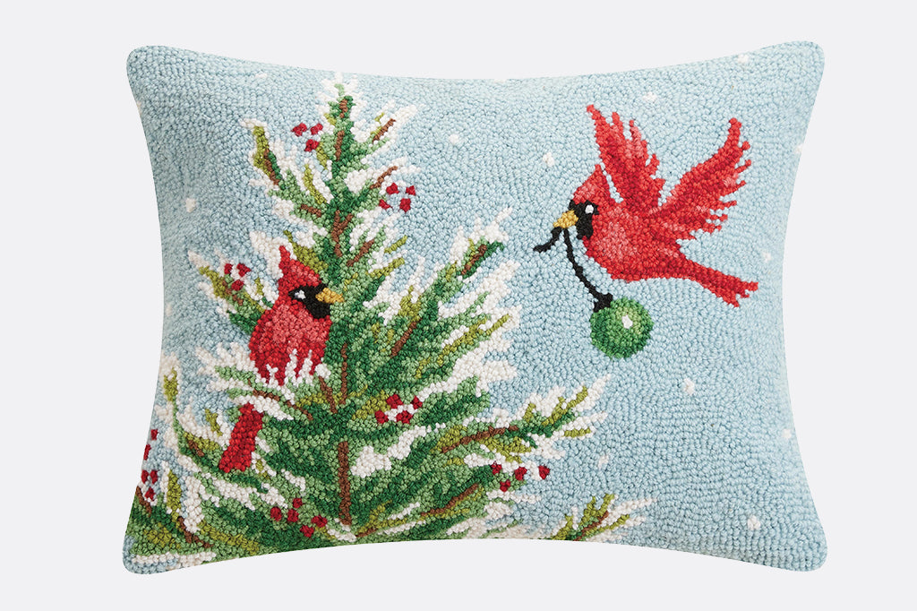 holiday tree being decorated by two cardinal hooked pillow 