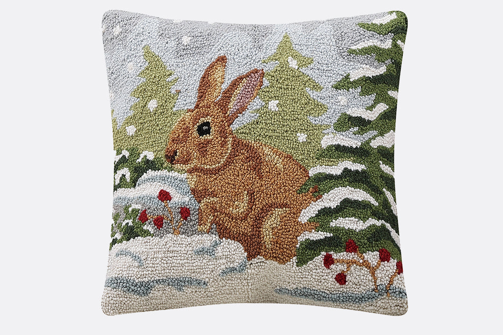 brown bunny in snowy forest scene hooked pillow 