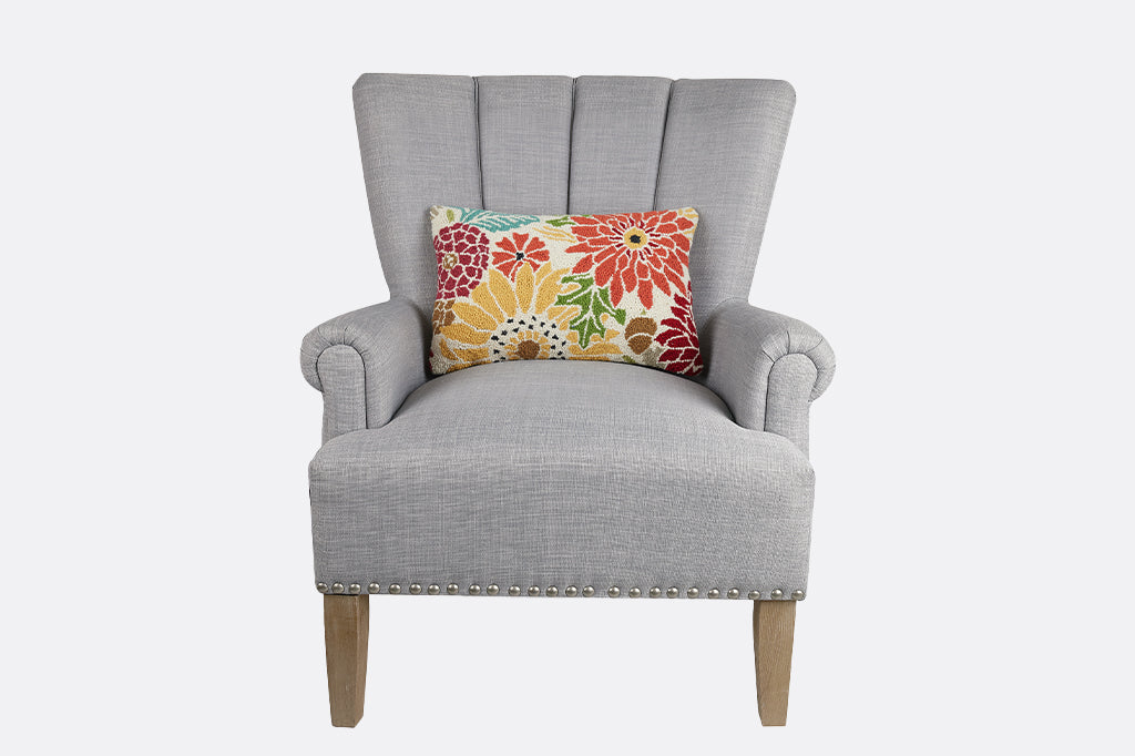 grey chair with lumbar pillow of dahlia motif in hooked wool