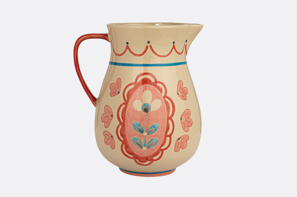 ceramic pitcher, adorned with a French folk art floral design in pretty pinks and blues on a cream background