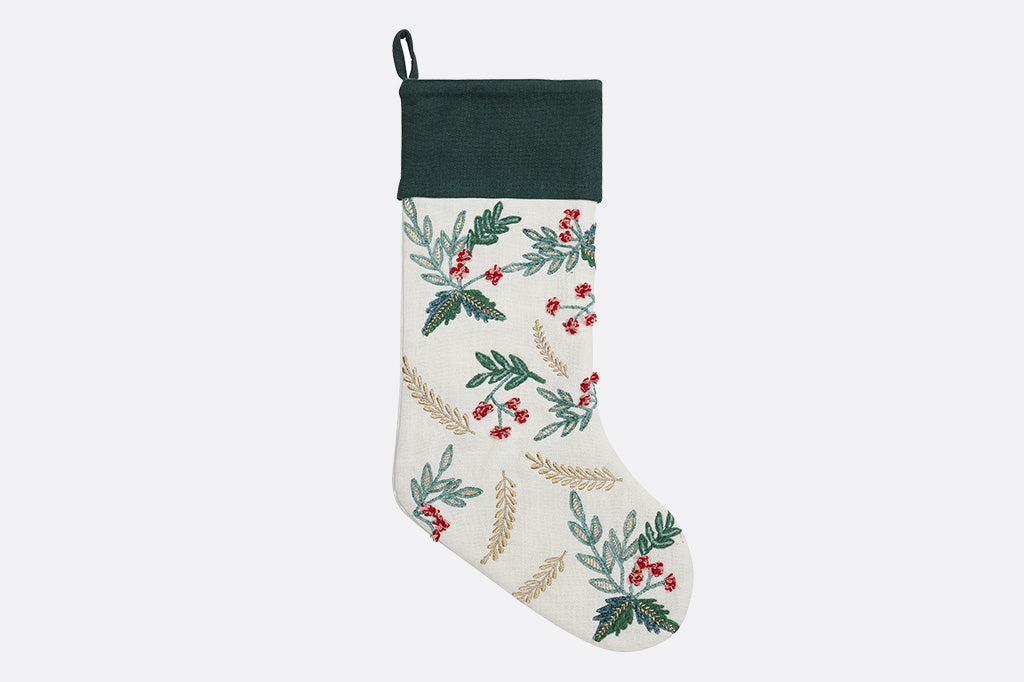 Decorative Christmas stocking with holly and leaf pattern on a white background