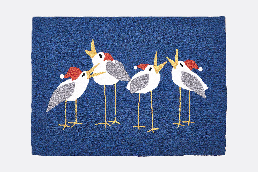 Blue rug with embroidered birds wearing red santa hats on a white background