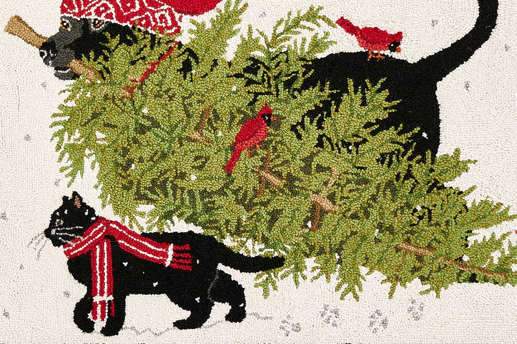 close-up detail of hooked wool on a doormat showing a cat, dog, and cardinals with a christmas tree