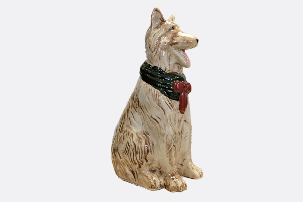 Dog bud vase with a green collar and red bow on a white background