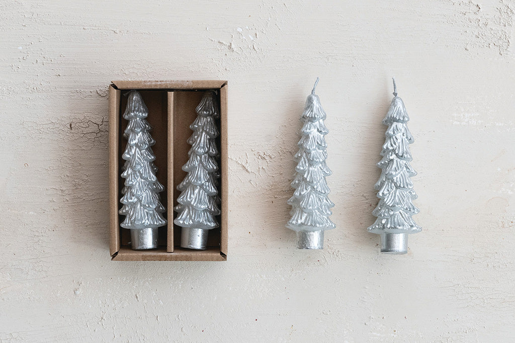 4 Silver tree-shaped candles with two in a box on a light background