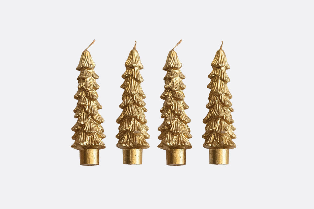 Four gold Christmas tree-shaped candles on a white background