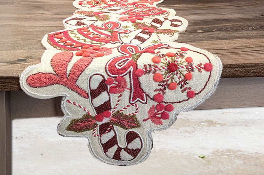 Decorative Christmas table runner with candy cane and bow design on a wooden table.