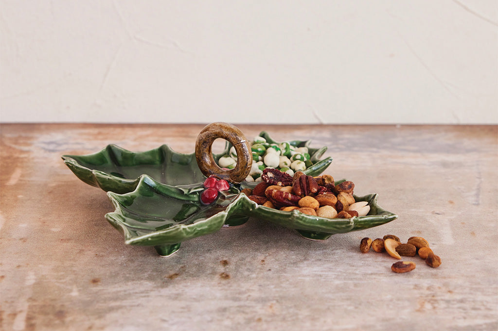 Green leaf-shaped ceramic dish with snacks on a wooden surface