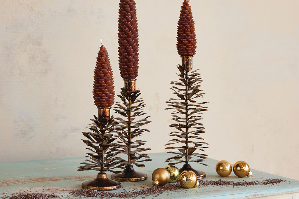 Tree shaped taper candleholders shown on holiday display with ornaments, glitter and pinecone candles