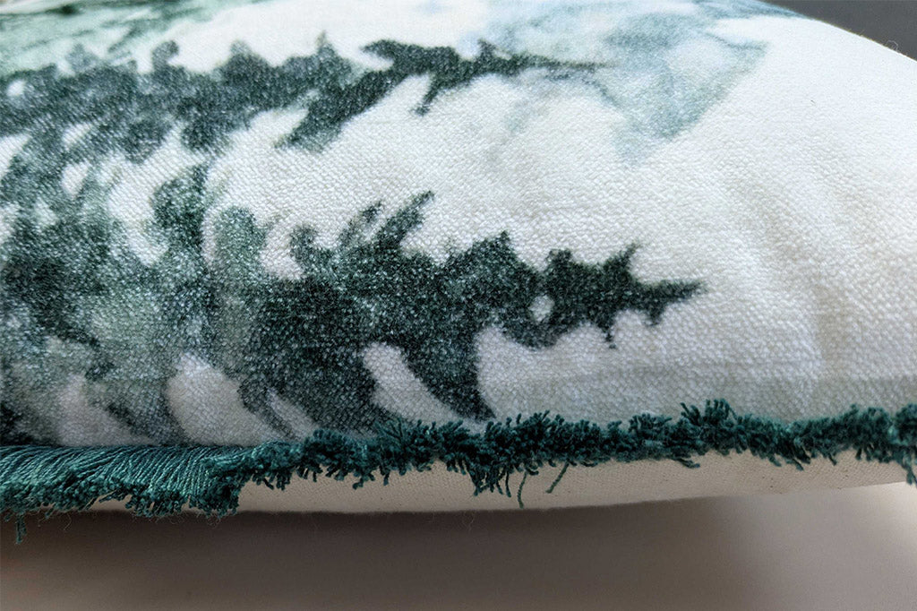 Close-up of a textured fabric with green and white patterns, green side fringe