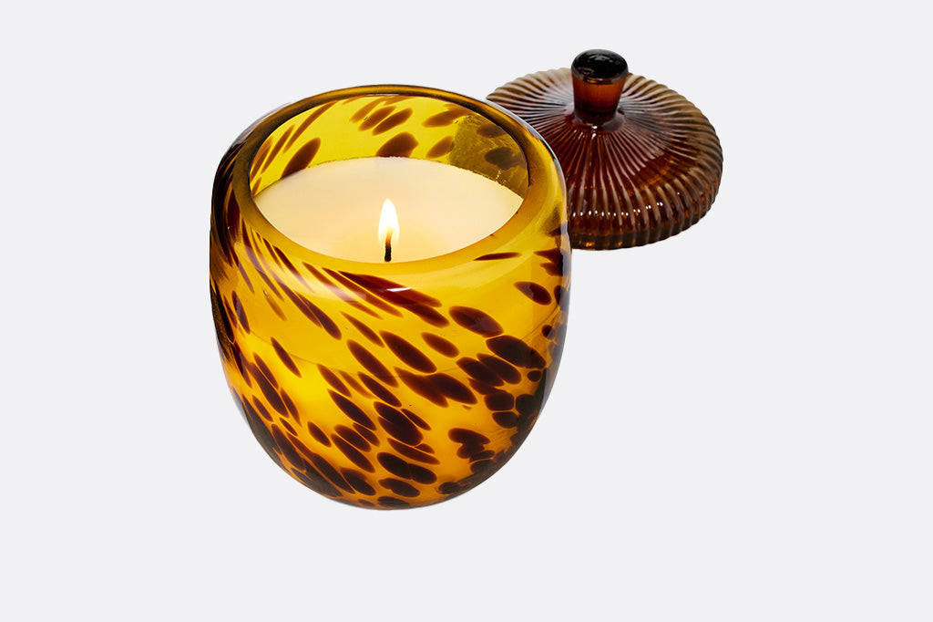 Tortoiseshell-patterned candle jar with an acorn shape lid on a white background