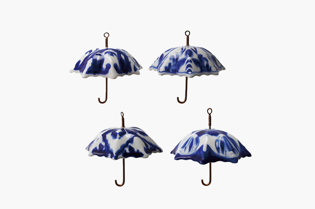 Four blue and white umbrella-shaped decorations on a white background