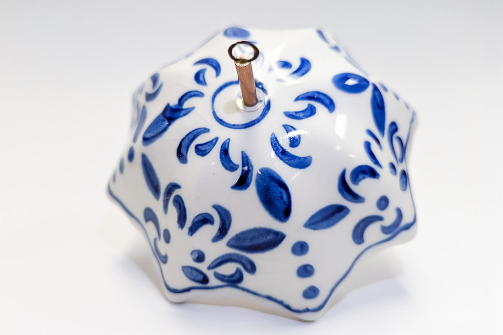Decorative ceramic umbrella ornament with blue patterns on a white background