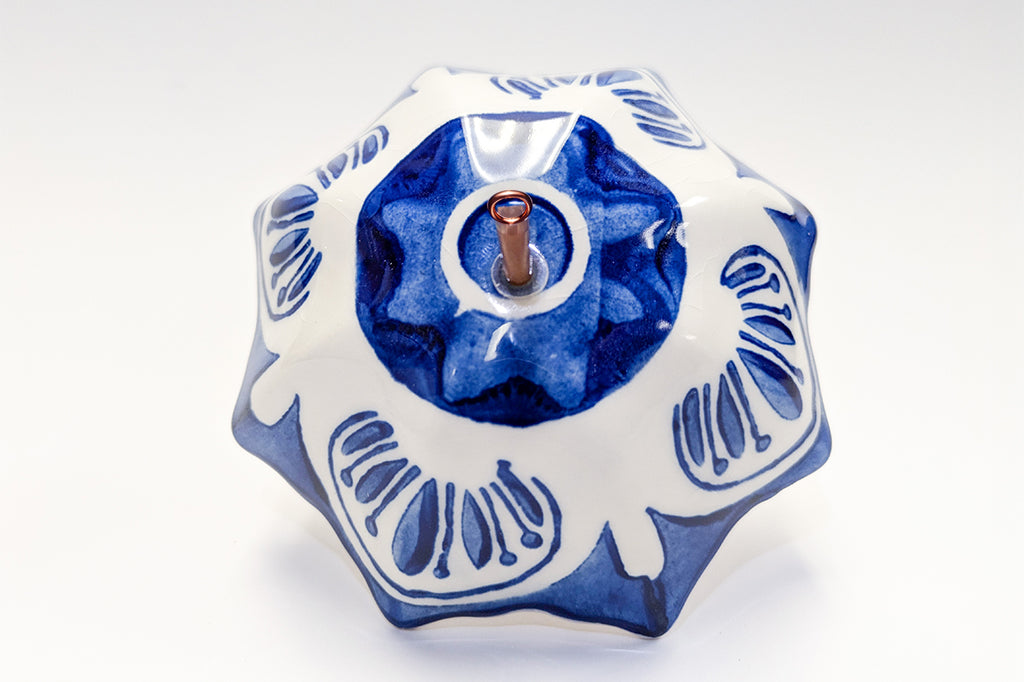 Decorative ceramic umbrella ornament with blue patterns on a white 