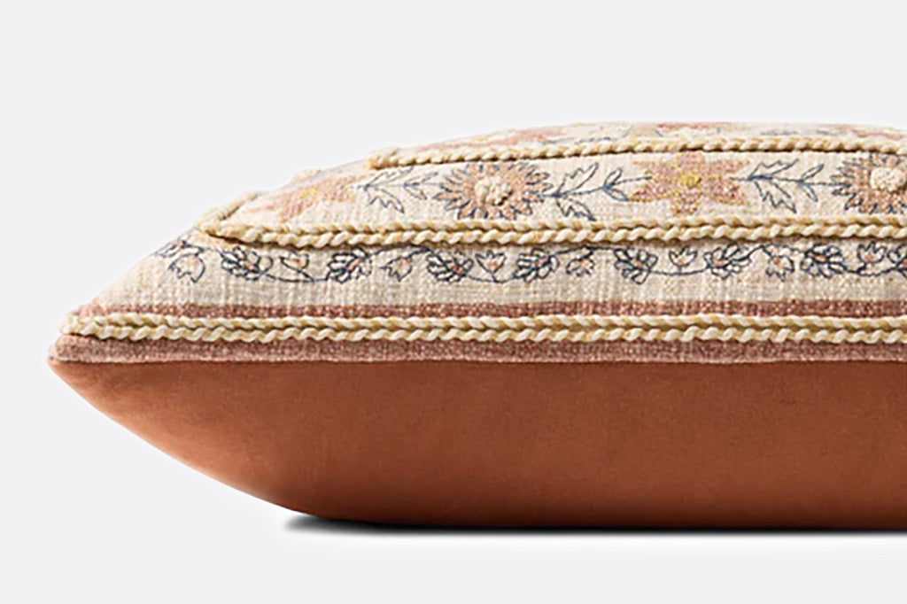 Decorative pillow with floral embroidery on a plain background