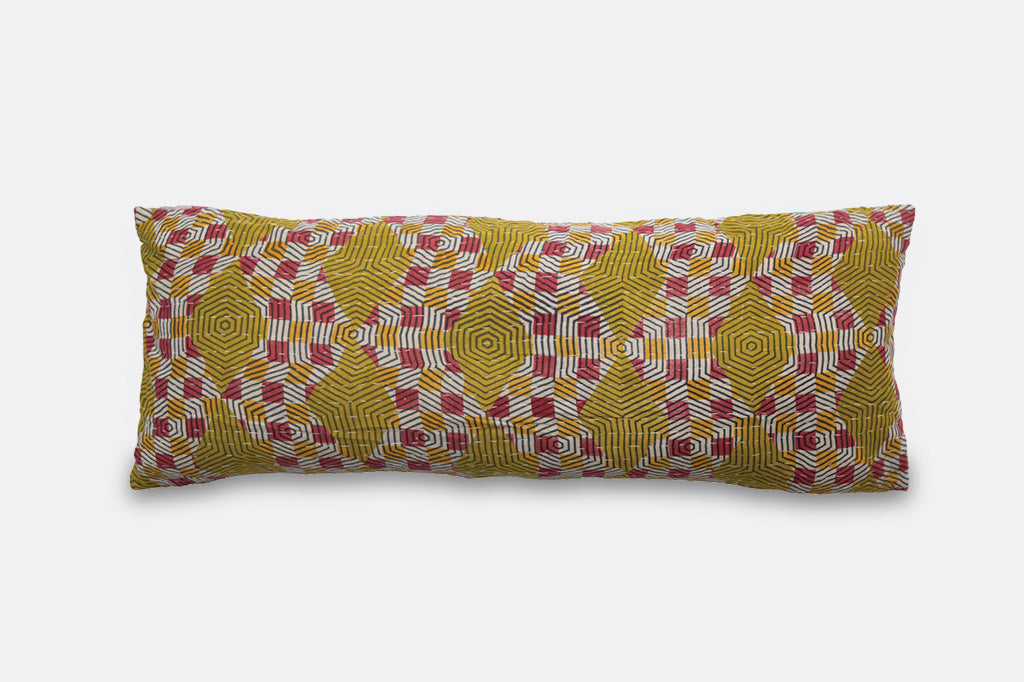 A patchwork pillow inscribed with the phrase "Sleeps with dogs."