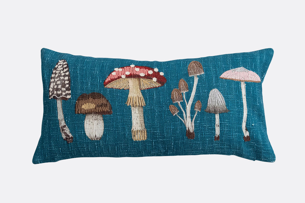 Decorative pillow with embroidered mushrooms on a blue background