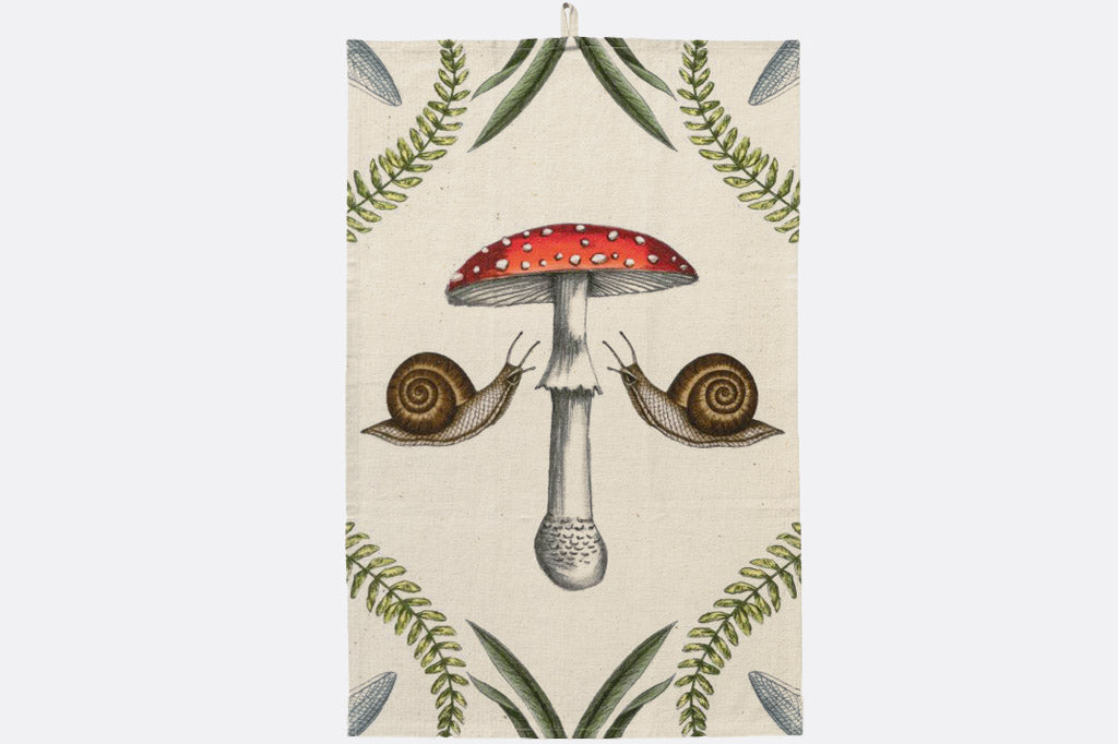 Tea towel with a red mushroom and snails design on a beige background