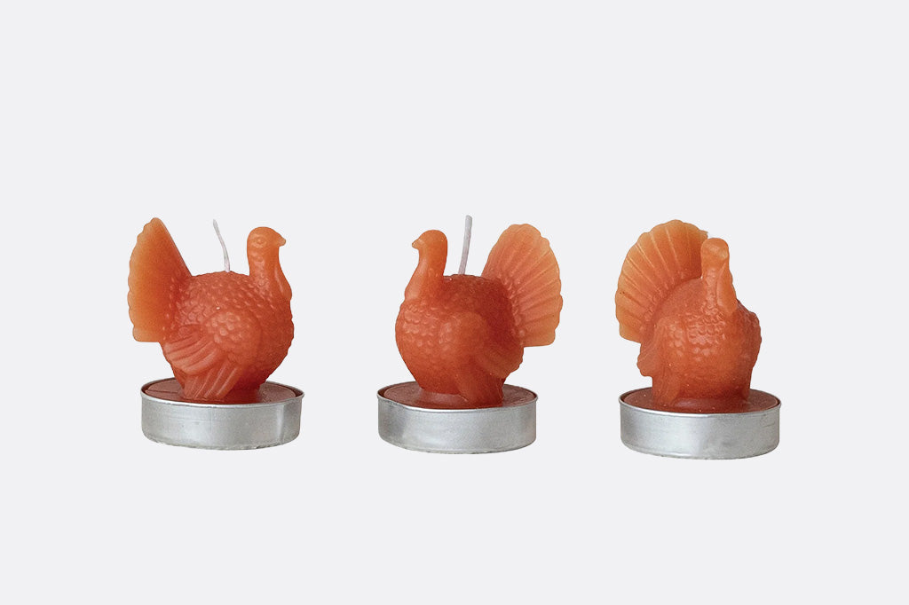 Three turkey-shaped candles on a white background