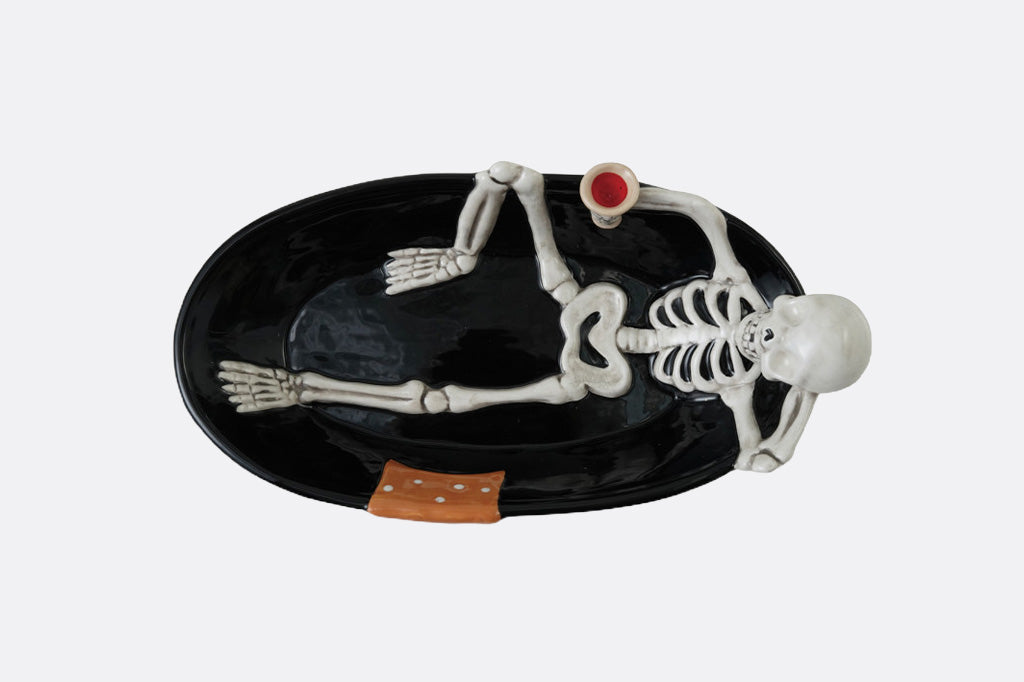 Skeletal design on a black oval plate with a white background