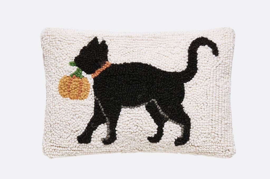 black cat with orange pumpkin in mouth on hooked pillow