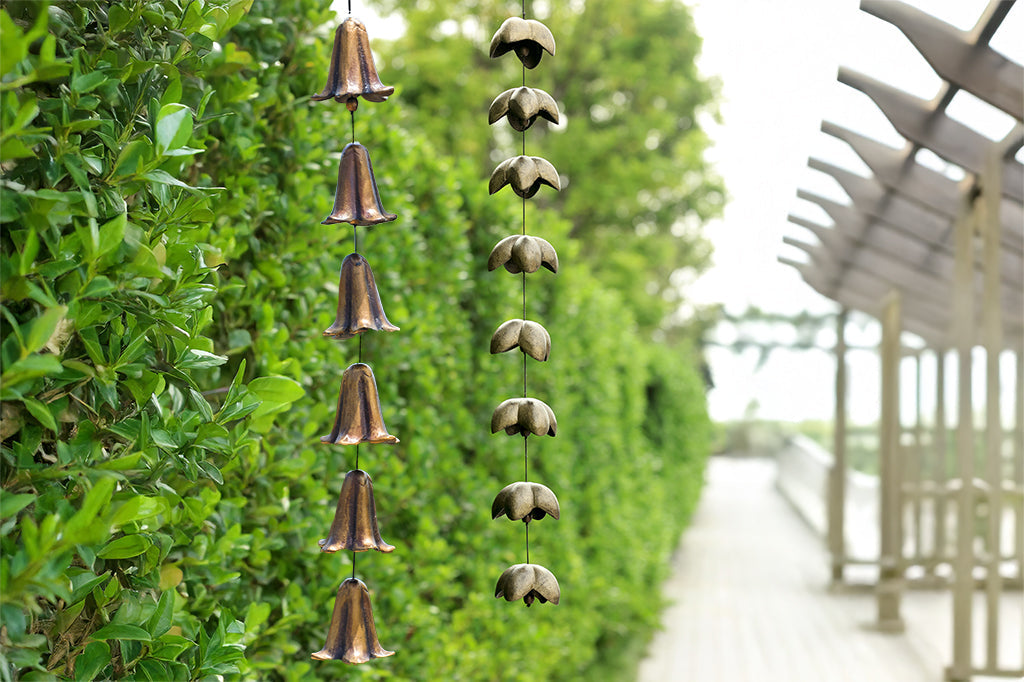 Decorative wind art with hanging blossom bells hanging among green bushes