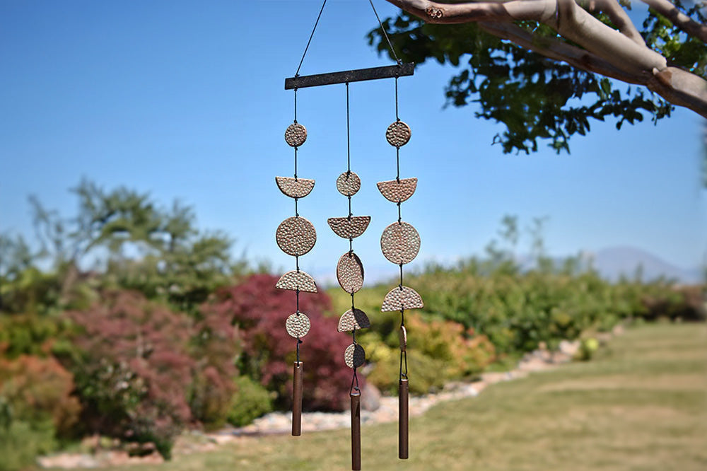 viento wind art shown suspended from backyard tree on sunny day