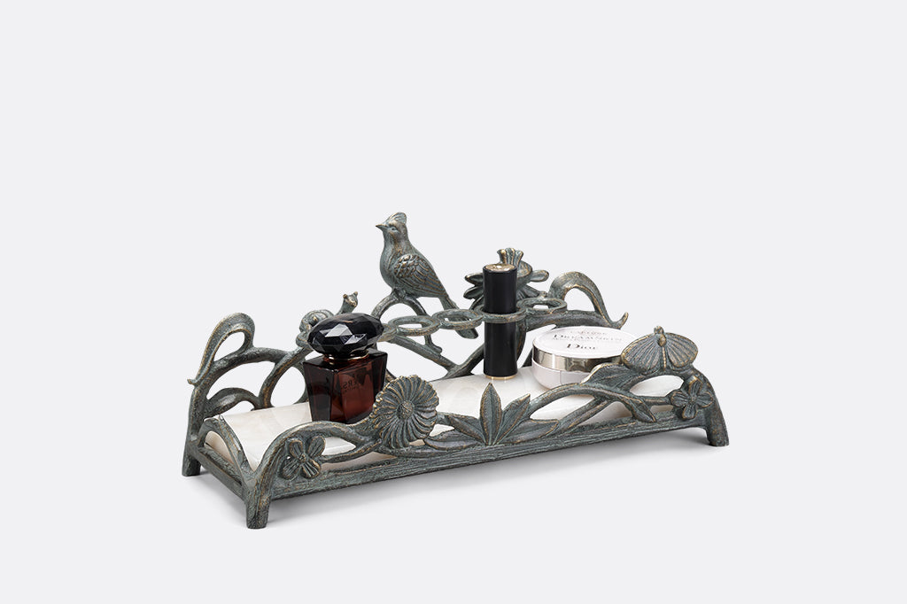 metal vanity tray with floral, bird and snail detailing. Special rings to hold lipsticks and a white marble base. 