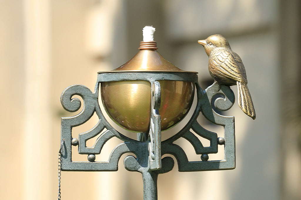 Mission style motif of scrollwork and bird on a garden oil torch on stake