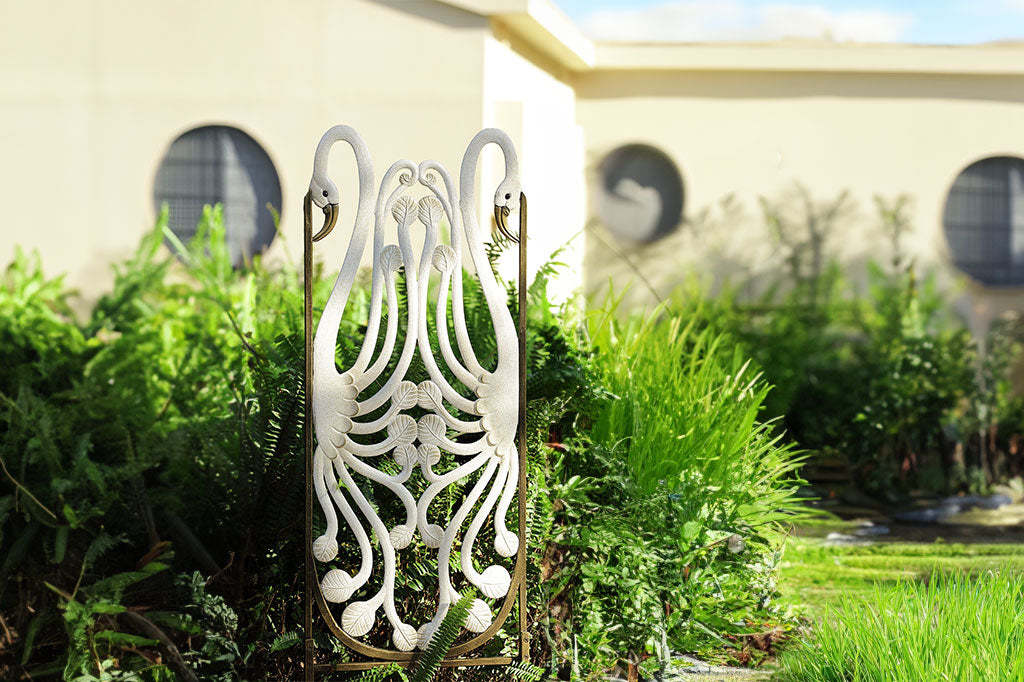 Art Nouveau  style trellis featuring 2 swans in white with bronze spatter highlights, featured in garden setting