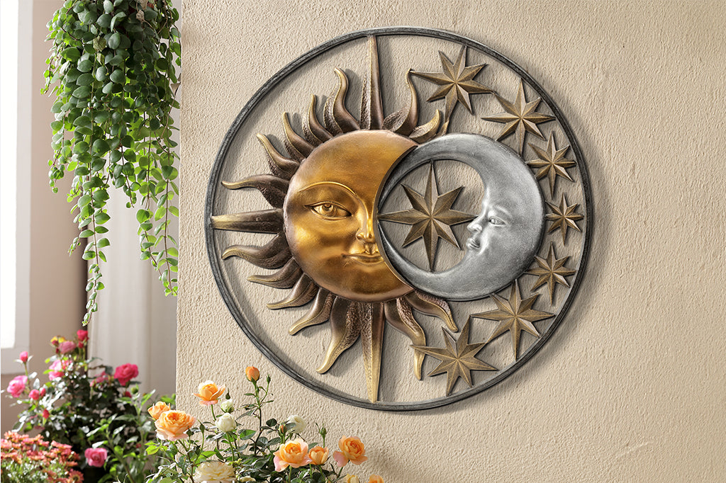 Sun and moon and stars enclosed in circular wall plaque, shown hanging on wall surrounded by house plants