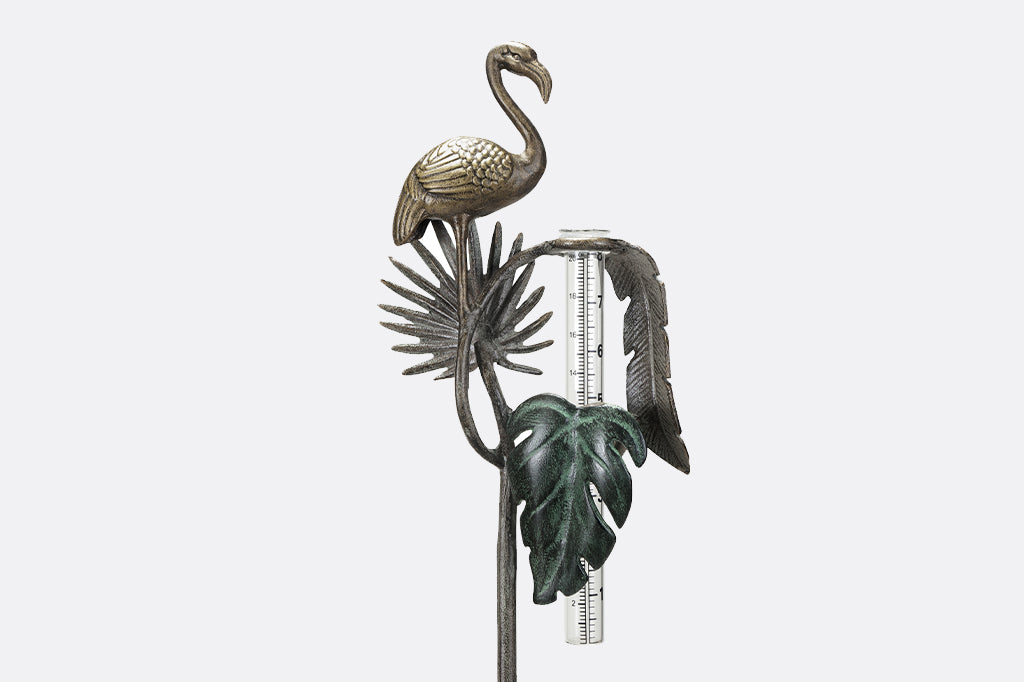 decorative garden rain catcher shows cast metal flamingo, and 3 tropical leaf accents