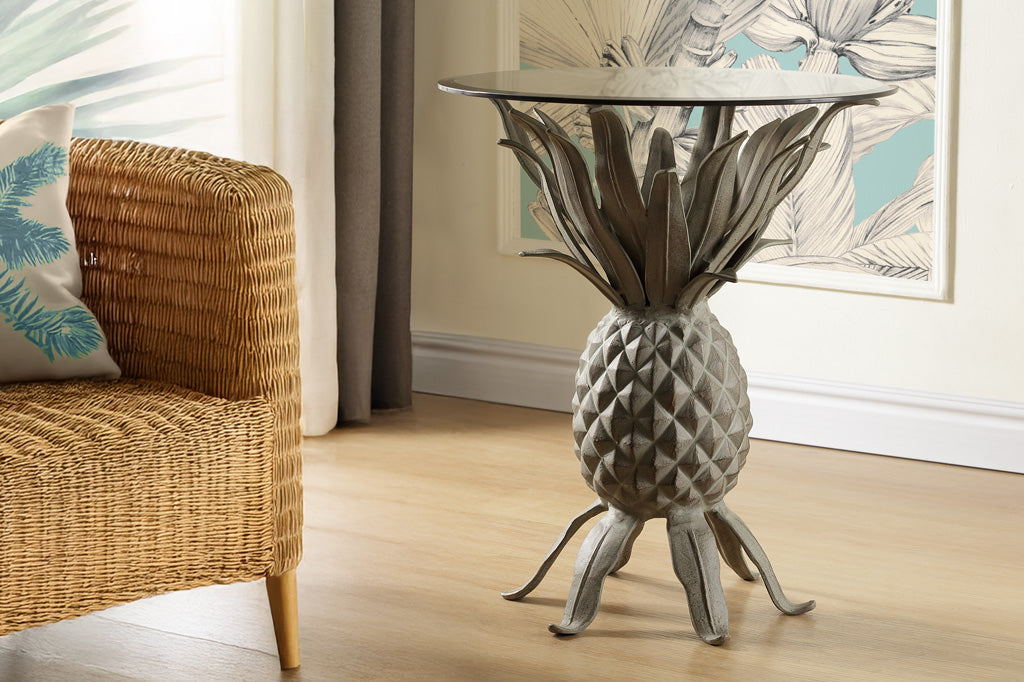 pineapple theme accent table shown in tropical themed living room with rattan loveseat