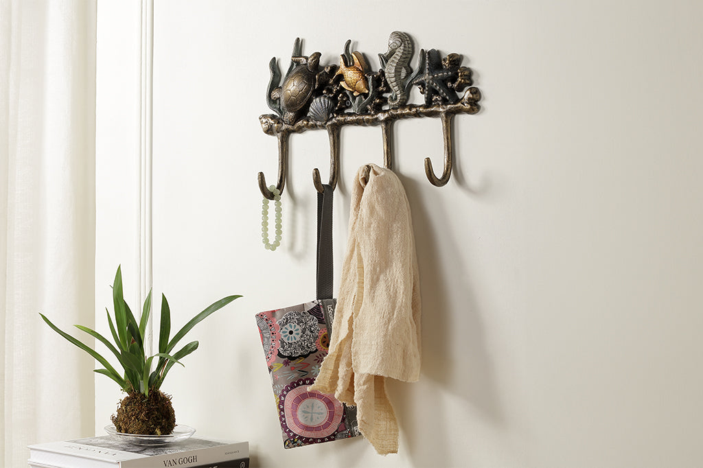 Metal wall hook featuring sea turtle, fish, seahorse, and starfish staged on wall 