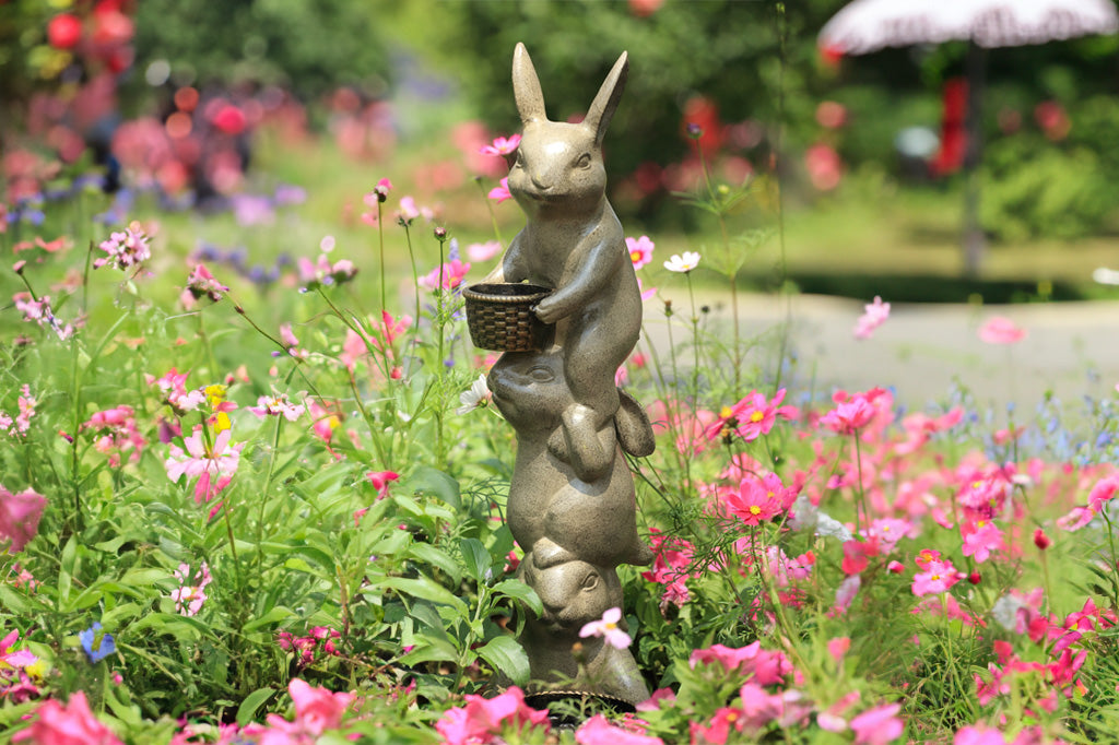 cast metal trio bunny stacked planter with two planters. one at base of sculpture the other in the paws on top bunny , shown in wildflower garden 