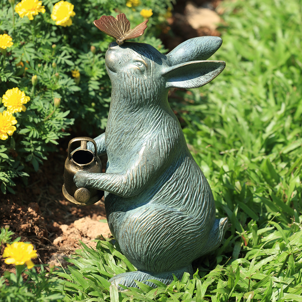 garden sculpture of bunny holding watering can looking at butterfly perched on nose