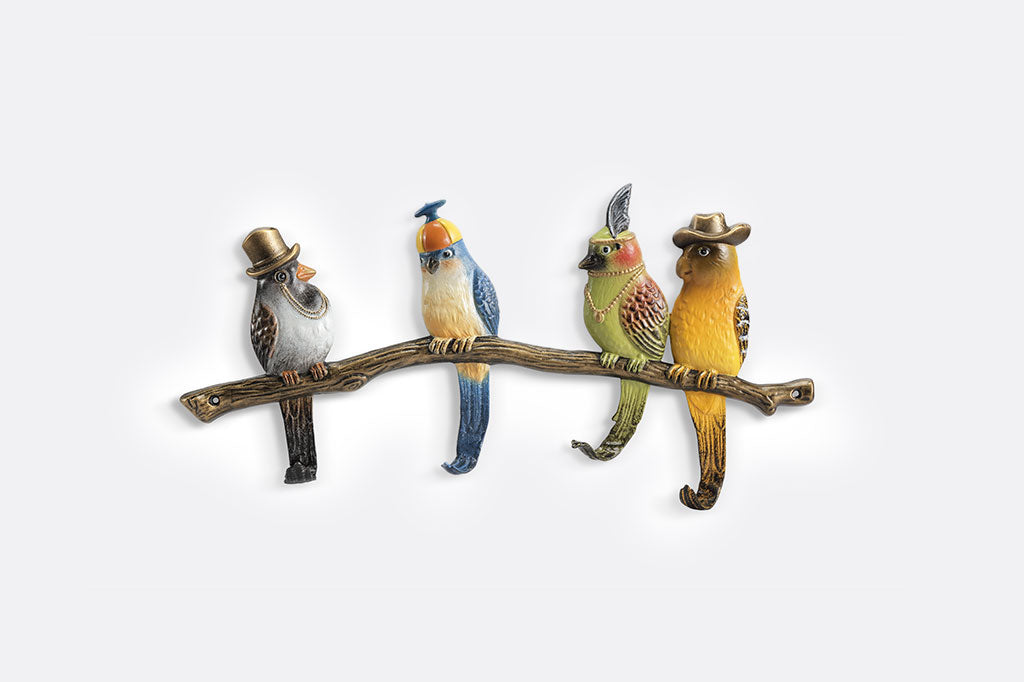 Four sculpted birds on a branch wear stylish headwear; their tailfeathers serve as hooks.They each wear a different hat: tophat, propeller beanie, feather headband, cowboy hat.