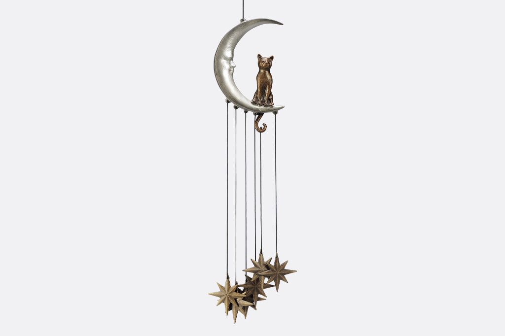 Wind art featuring a cat seated upon a crescent moon with face, 8 point star pendants suspended below. 