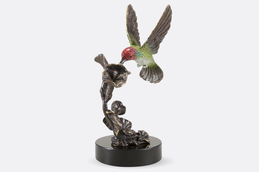 cast brass red and green hummingbirds hovering above flowers