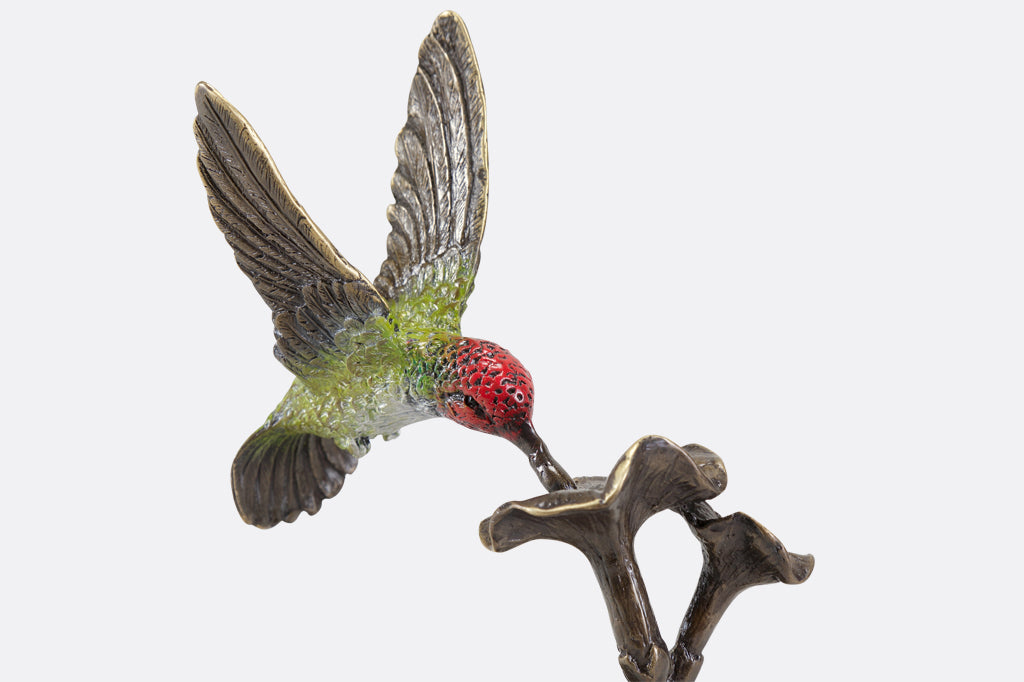 cast brass red and green hummingbirds hovering above flowers