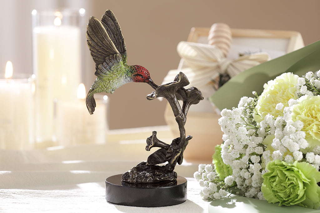 cast brass red and green hummingbirds hovering above flowers