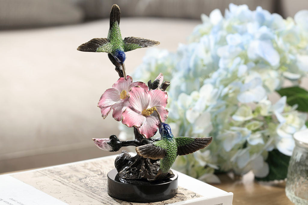 Brass hummingbird sculpture with pink blossoms, indoor sculpture shown on table with hydrangeas