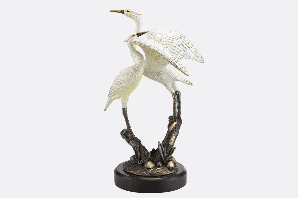 Statue of two cranes on a white background
