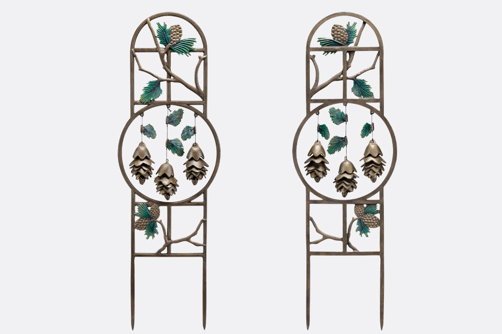 Front and back views of pinetree theme garden trellis with 3 pinecone shaped pendants hanging within sculptural hoop. 