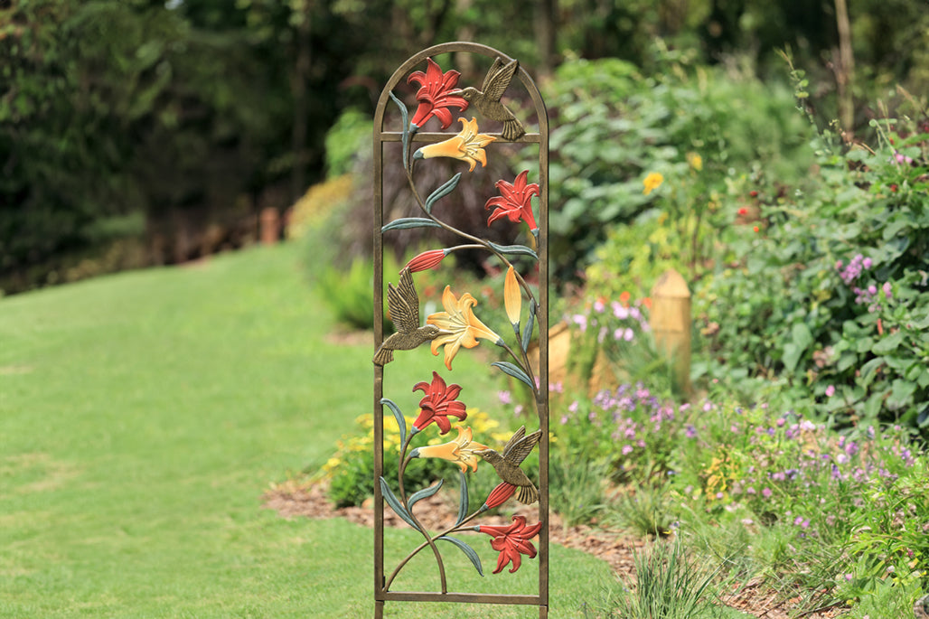 trellis shown in garden with coral and yellow lilies and a hummingbird motif