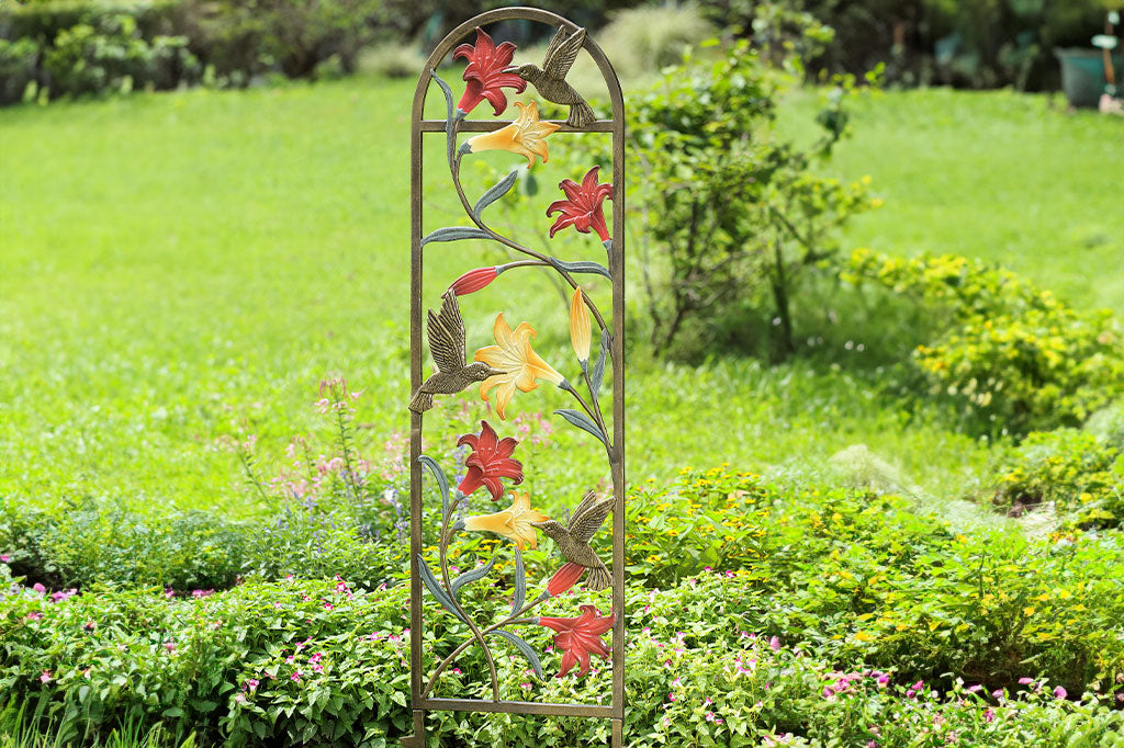 trellis shown in garden with coral and yellow lilies and a hummingbird motif