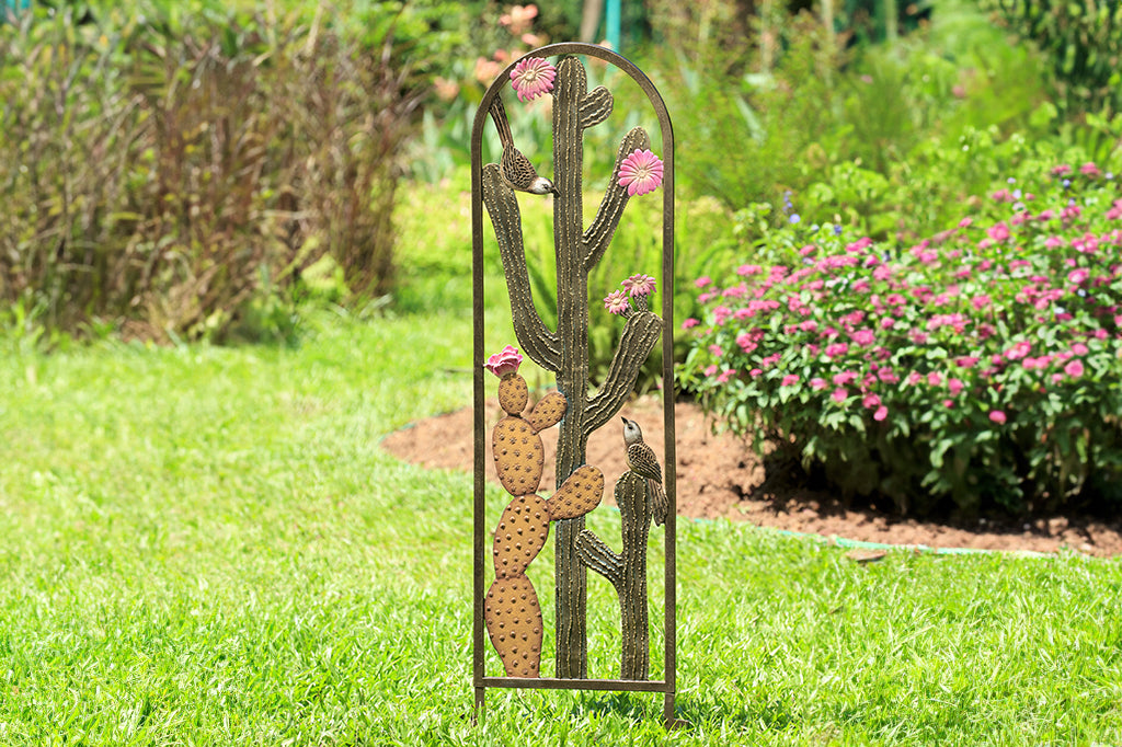 Cast metal trellis with cactus and blooms detailing, shown in garden with blooming bushes