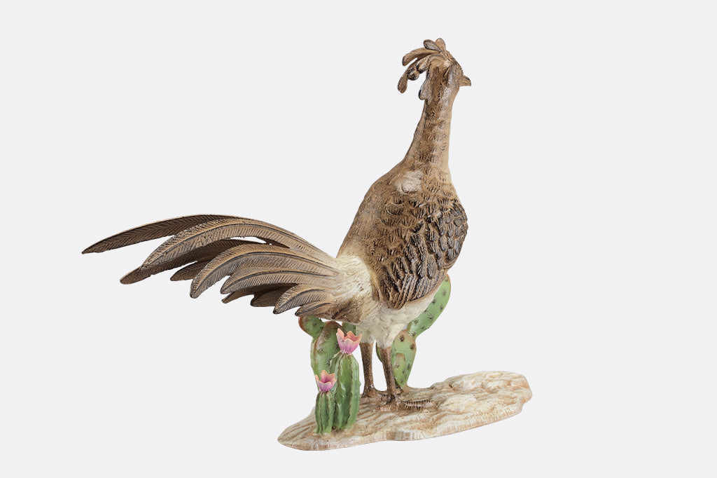 A statue of a roadrunner stood between a group of cacti.